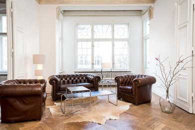 Großes, Repräsentatives, Fernseherloses Klassisches Wohnzimmer ohne Kamin mit weißer Wandfarbe und braunem Holzboden in Berlin