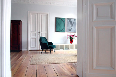 Mittelgroßes, Abgetrenntes Modernes Wohnzimmer mit braunem Holzboden und grauer Wandfarbe in Berlin