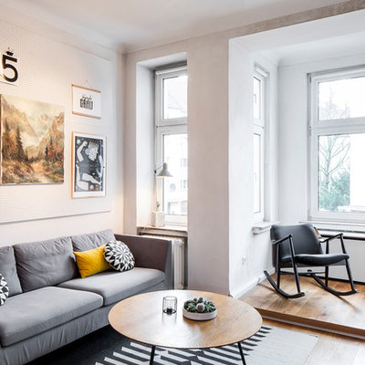 Mid-sized danish enclosed medium tone wood floor and brown floor family room photo in Cologne with white walls and no fireplace