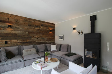 Mittelgroßes, Fernseherloses, Abgetrenntes Rustikales Wohnzimmer mit grauer Wandfarbe, Kaminofen und beigem Boden in München