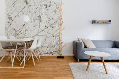 Пример оригинального дизайна: открытая гостиная комната в скандинавском стиле с светлым паркетным полом и коричневым полом