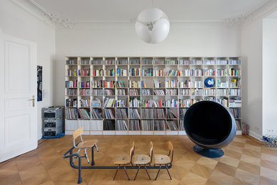 Mittelgroße, Abgetrennte Moderne Bibliothek mit weißer Wandfarbe und braunem Holzboden in Berlin
