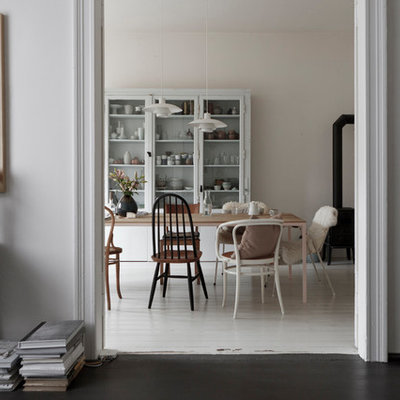 Mid-sized danish enclosed dark wood floor and black floor family room photo in Leipzig with white walls, a wood stove, a tile fireplace and no tv