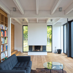 Abgetrennte, Mittelgroße Moderne Bibliothek mit weißer Wandfarbe, braunem Holzboden, Kamin und braunem Boden in Hamburg