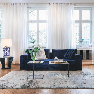 Geräumiges, Offenes, Fernseherloses Eklektisches Wohnzimmer ohne Kamin mit braunem Holzboden, braunem Boden und weißer Wandfarbe in Berlin