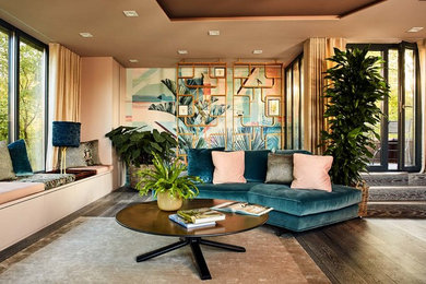 Foto de sala de estar abierta bohemia de tamaño medio sin chimenea y televisor con paredes beige, suelo de madera oscura y suelo marrón