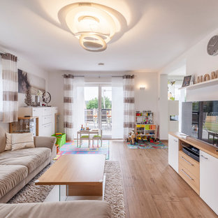 Mittelgroßes, Offenes Modernes Wohnzimmer ohne Kamin mit weißer Wandfarbe, braunem Holzboden, freistehendem TV und braunem Boden in Sonstige
