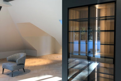 Mittelgroßes, Repräsentatives, Offenes Modernes Wohnzimmer mit grauer Wandfarbe, gebeiztem Holzboden, grauem Boden und freigelegten Dachbalken in Berlin
