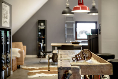 Kleines, Offenes Industrial Wohnzimmer mit grauer Wandfarbe, Laminat, Kaminofen, TV-Wand und grauem Boden in München
