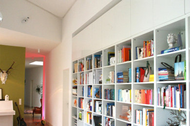 Idee per un ampio soggiorno design aperto con libreria e pavimento in legno massello medio