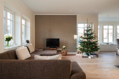 На фото: гостиная комната в скандинавском стиле с разноцветными стенами, светлым паркетным полом и отдельно стоящим телевизором