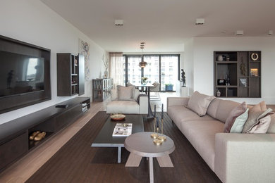 Offenes Modernes Wohnzimmer ohne Kamin mit weißer Wandfarbe, TV-Wand und hellem Holzboden in Frankfurt am Main