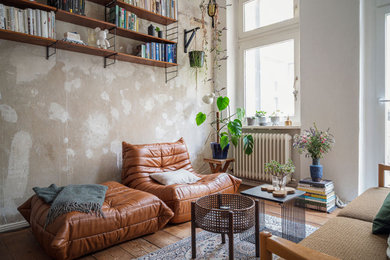 Mittelgroßes, Fernseherloses, Abgetrenntes Stilmix Wohnzimmer mit beiger Wandfarbe, braunem Holzboden und braunem Boden in Berlin