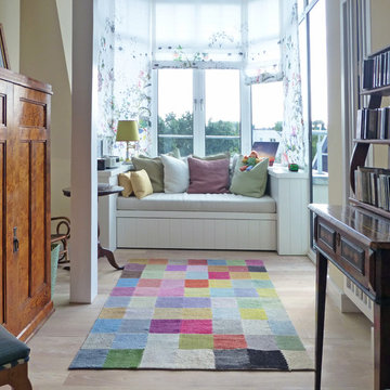 Bibliothek mit schönem Kelim in vielen schönen Farben auf hellem Holzboden