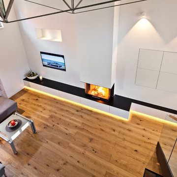 Blick von der Galerie: Kamin als Loft-Wohnwärmemöbel® mit Stauraum und Medientec
