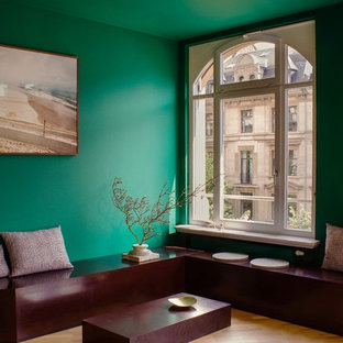 Mittelgroßes Modernes Wohnzimmer mit grüner Wandfarbe, braunem Holzboden und braunem Boden in Frankfurt am Main