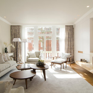 Großes, Repräsentatives, Offenes Stilmix Wohnzimmer mit beiger Wandfarbe, hellem Holzboden, Gaskamin, Kaminumrandung aus Stein, verstecktem TV und beigem Boden in London