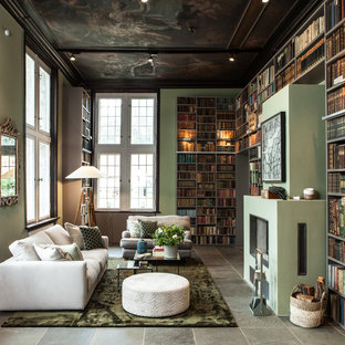 Fernseherlose, Große Moderne Bibliothek im Loft-Stil mit grüner Wandfarbe, verputzter Kaminumrandung, Gaskamin und grauem Boden in Hamburg