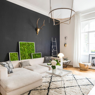 Mittelgroßes, Repräsentatives, Fernseherloses, Abgetrenntes Skandinavisches Wohnzimmer ohne Kamin mit schwarzer Wandfarbe, hellem Holzboden und beigem Boden in München