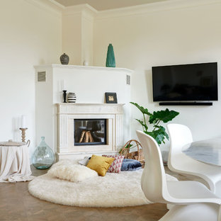 Mittelgroßes, Abgetrenntes Modernes Wohnzimmer mit weißer Wandfarbe, braunem Holzboden, Kamin, Kaminumrandung aus Stein, Wand-TV und braunem Boden in Berlin
