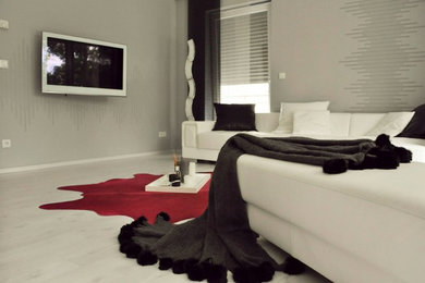 Offenes, Mittelgroßes Modernes Wohnzimmer mit grauer Wandfarbe, TV-Wand, Laminat, weißem Boden und Tapetenwänden in Sonstige