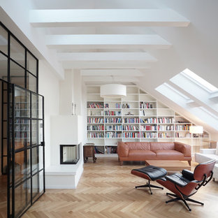 Große, Abgetrennte Moderne Bibliothek mit weißer Wandfarbe, braunem Holzboden, Tunnelkamin, verputzter Kaminumrandung und braunem Boden in Berlin