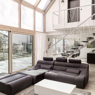 Geräumiges, Fernseherloses Modernes Wohnzimmer im Loft-Stil, ohne Kamin mit Betonboden, weißer Wandfarbe und grauem Boden in Sonstige