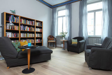 Große, Abgetrennte Moderne Bibliothek mit blauer Wandfarbe, hellem Holzboden und braunem Boden in Nürnberg
