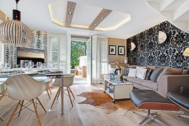 Offenes, Mittelgroßes Modernes Wohnzimmer ohne Kamin mit bunten Wänden, hellem Holzboden und freistehendem TV in Sonstige