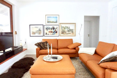 Offenes, Mittelgroßes Stilmix Wohnzimmer mit weißer Wandfarbe, Kamin, freistehendem TV, Porzellan-Bodenfliesen, gefliester Kaminumrandung und beigem Boden in Berlin