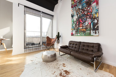 Cette photo montre une petite salle de séjour tendance ouverte avec un mur multicolore et un sol en bois brun.
