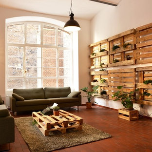 Mittelgroßes, Fernseherloses Industrial Wohnzimmer ohne Kamin, im Loft-Stil mit weißer Wandfarbe und rotem Boden in Berlin
