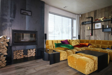 ケルンにあるラグジュアリーな広いインダストリアルスタイルのおしゃれなLDK (グレーの壁、濃色無垢フローリング、標準型暖炉、金属の暖炉まわり、壁掛け型テレビ、茶色い床) の写真