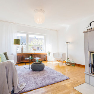 Mittelgroßes, Repräsentatives, Fernseherloses, Abgetrenntes Modernes Wohnzimmer mit weißer Wandfarbe, braunem Holzboden, Kamin, gefliester Kaminumrandung und braunem Boden in Sonstige