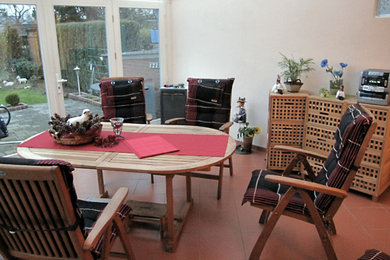Modelo de salón abierto tradicional de tamaño medio sin chimenea y televisor con paredes beige, suelo de baldosas de terracota y suelo rojo