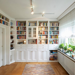 Abgetrennte Klassische Bibliothek mit weißer Wandfarbe, braunem Holzboden und braunem Boden in Dortmund