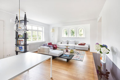 Mittelgroßes, Fernseherloses, Offenes Modernes Wohnzimmer ohne Kamin mit weißer Wandfarbe, hellem Holzboden und beigem Boden in Köln