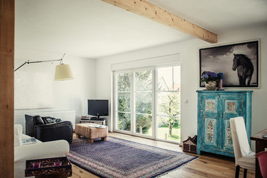 Shabby-Look Wohnzimmer mit weißer Wandfarbe, braunem Holzboden und braunem Boden in Stuttgart