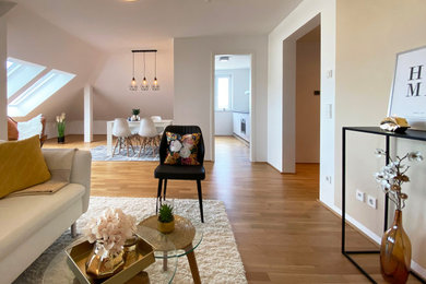 Geräumiges, Offenes Modernes Wohnzimmer ohne Kamin mit weißer Wandfarbe, hellem Holzboden und TV-Wand in Sonstige