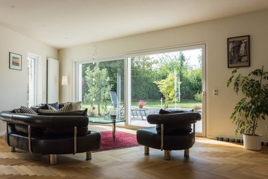 Großes, Offenes Klassisches Wohnzimmer ohne Kamin mit weißer Wandfarbe, braunem Holzboden und braunem Boden in Dortmund