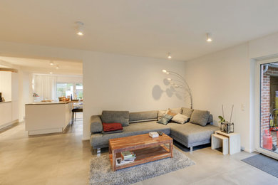 Geräumiges, Offenes Modernes Wohnzimmer mit weißer Wandfarbe, Porzellan-Bodenfliesen und grauem Boden