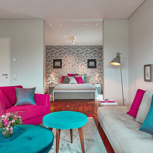 Mittelgroßes, Repräsentatives, Fernseherloses, Offenes Modernes Wohnzimmer ohne Kamin mit grauer Wandfarbe, braunem Holzboden und braunem Boden in Berlin