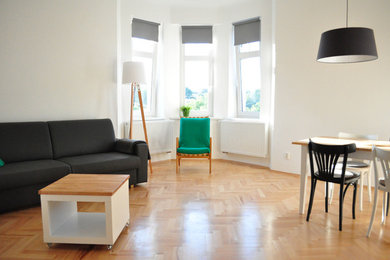 Großes, Abgetrenntes Modernes Wohnzimmer mit weißer Wandfarbe, braunem Holzboden, TV-Wand und braunem Boden in Berlin