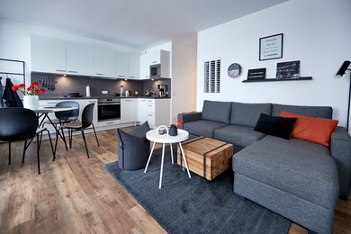 Mittelgroßes, Offenes, Repräsentatives Modernes Wohnzimmer ohne Kamin mit weißer Wandfarbe, braunem Holzboden und braunem Boden in Hamburg