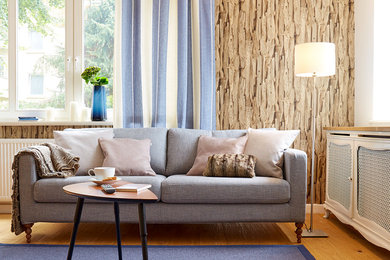 Skandinavisches Wohnzimmer mit brauner Wandfarbe und braunem Holzboden in München