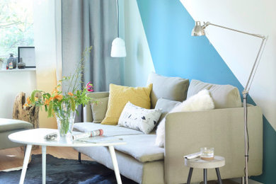 Ejemplo de sala de estar romántica con paredes multicolor y suelo de madera clara