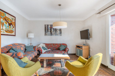 Mittelgroßes, Offenes Stilmix Wohnzimmer mit braunem Holzboden und TV-Wand in Bremen