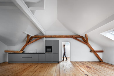 Großes Modernes Wohnzimmer mit hellem Holzboden, weißer Wandfarbe und braunem Boden in München