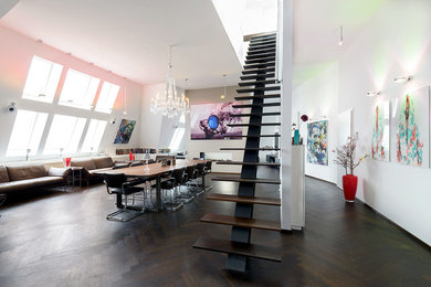 Großes Stilmix Wohnzimmer im Loft-Stil mit weißer Wandfarbe, dunklem Holzboden, verputzter Kaminumrandung, TV-Wand und Tunnelkamin in Hamburg