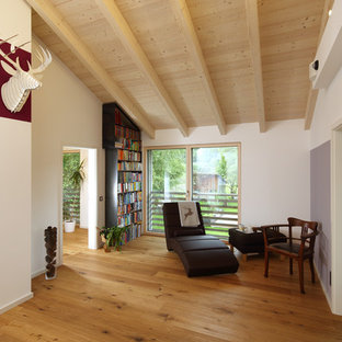 Mittelgroße, Fernseherlose, Abgetrennte Urige Bibliothek ohne Kamin mit weißer Wandfarbe, dunklem Holzboden und braunem Boden in München